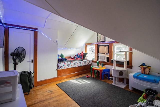 bedroom with hardwood / wood-style flooring, cooling unit, and lofted ceiling