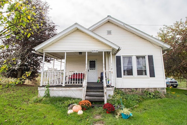 bungalow-style house featuring covered porch and a front yard