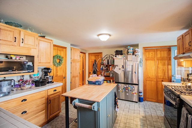 kitchen with tile counters and appliances with stainless steel finishes