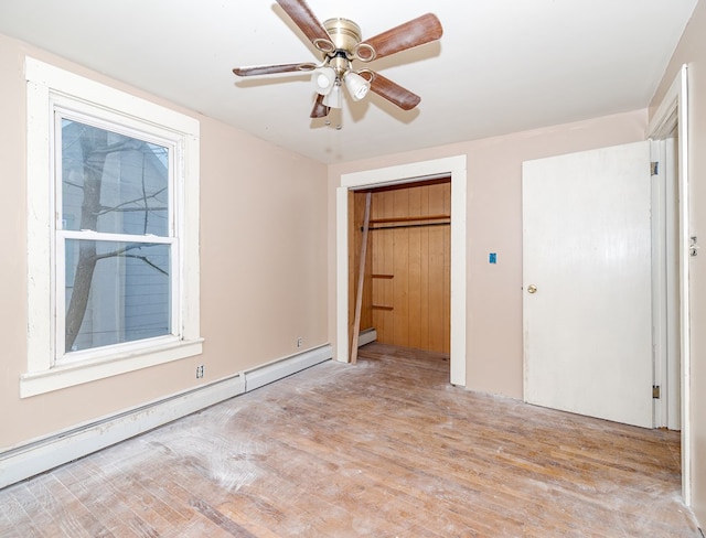 unfurnished bedroom with ceiling fan, light wood-type flooring, baseboard heating, and a closet