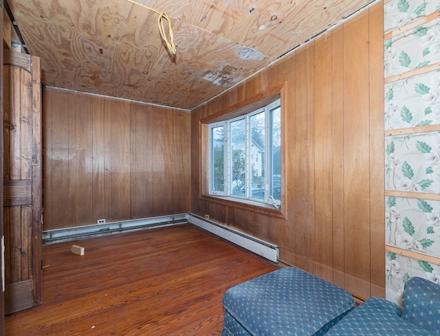 unfurnished room with baseboard heating, wooden walls, dark hardwood / wood-style flooring, and wooden ceiling