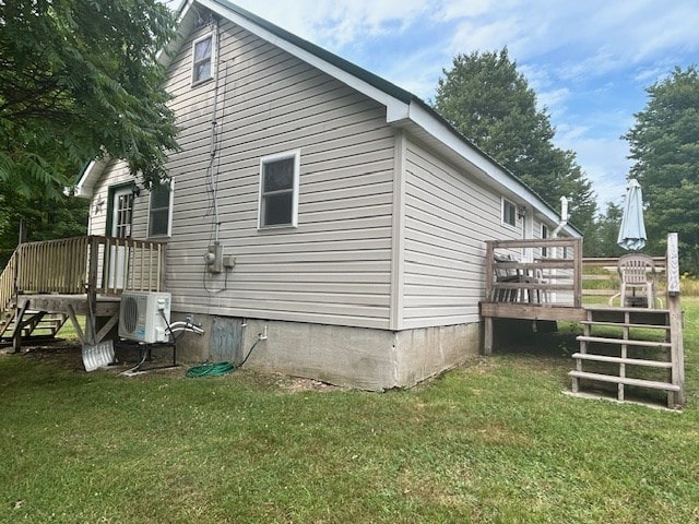 view of side of home with ac unit, a yard, and a wooden deck