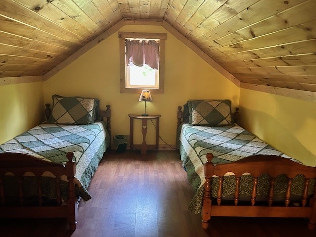 bedroom featuring wooden ceiling, vaulted ceiling, and hardwood / wood-style flooring