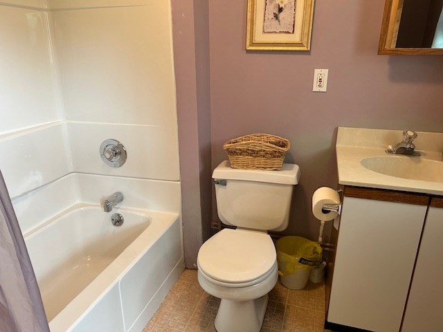 full bathroom featuring vanity, bathtub / shower combination, and toilet