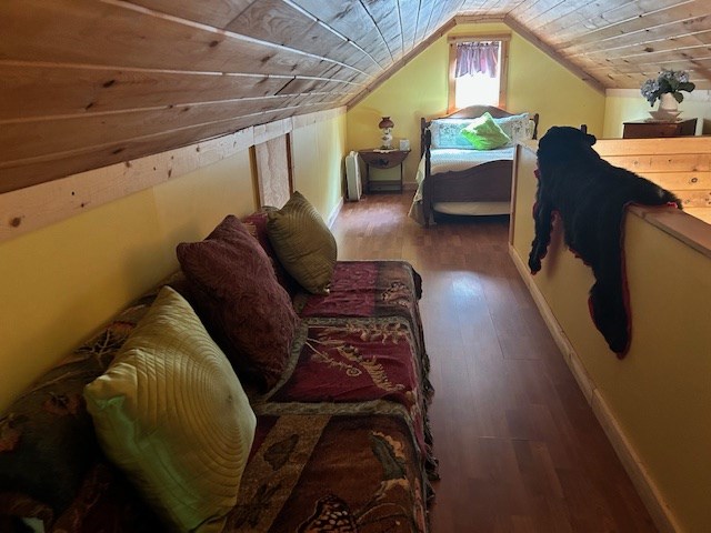 bedroom with hardwood / wood-style floors, wooden ceiling, and vaulted ceiling