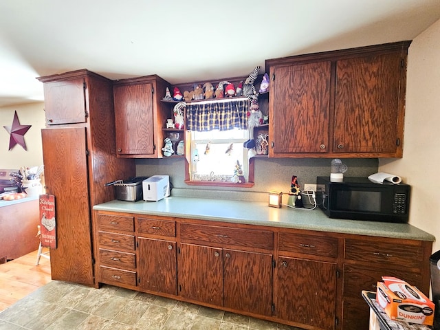 kitchen with black microwave, light countertops, and open shelves