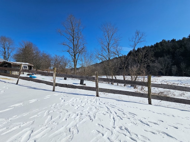 snowy yard featuring fence