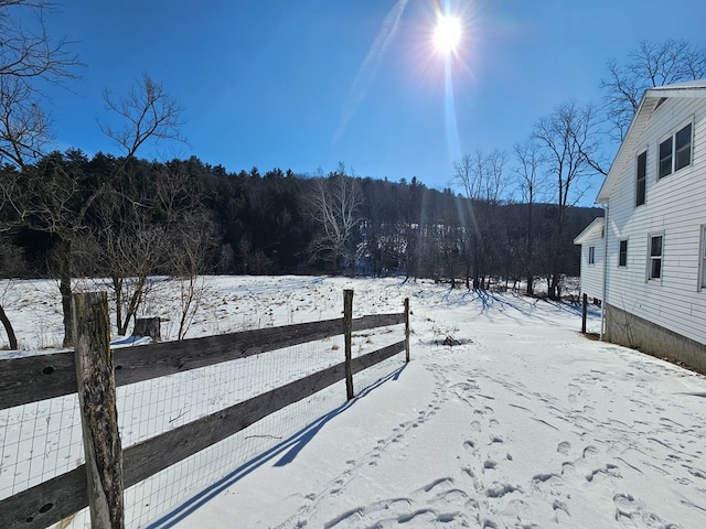 yard covered in snow featuring fence