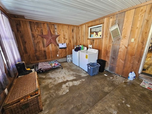 interior space featuring laundry area, separate washer and dryer, and wooden walls