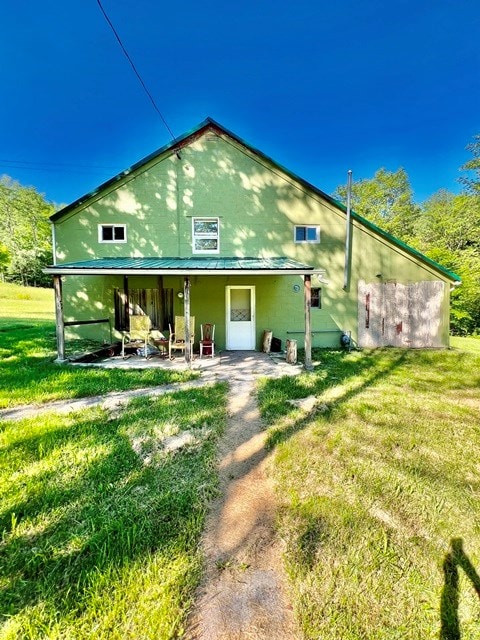 back of property with a yard and a patio