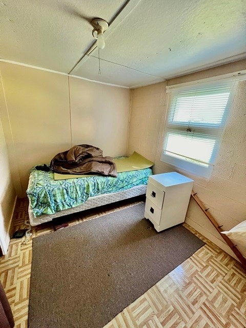 bedroom featuring light parquet floors and a textured ceiling