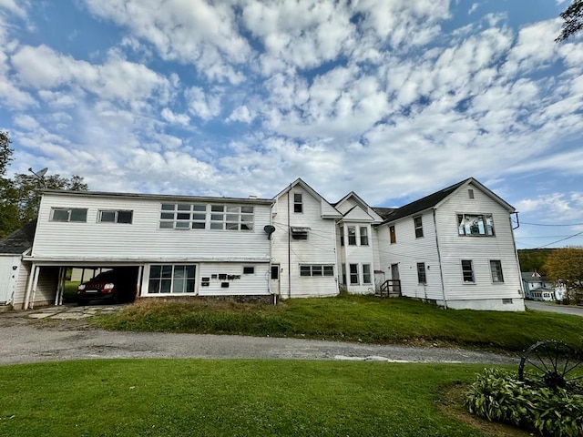 view of front of home with a front yard and a carport