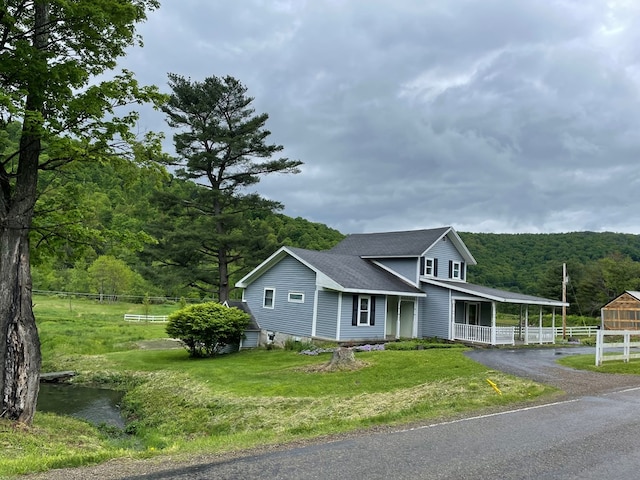 1571 State Route 44n, Coudersport, PA 16915 - view of front of home with covered porch, roof with shingles, and a forest view