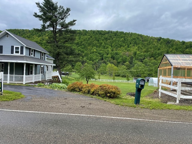 1571 State Route 44n, Coudersport, PA 16915 - view of side of home with a wooded view, an exterior structure, a porch, and an outdoor structure