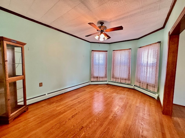 empty room with a wealth of natural light, light hardwood / wood-style floors, ceiling fan, and crown molding