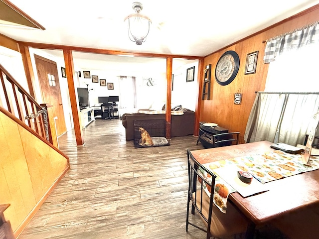 dining space featuring wood-type flooring and wooden walls