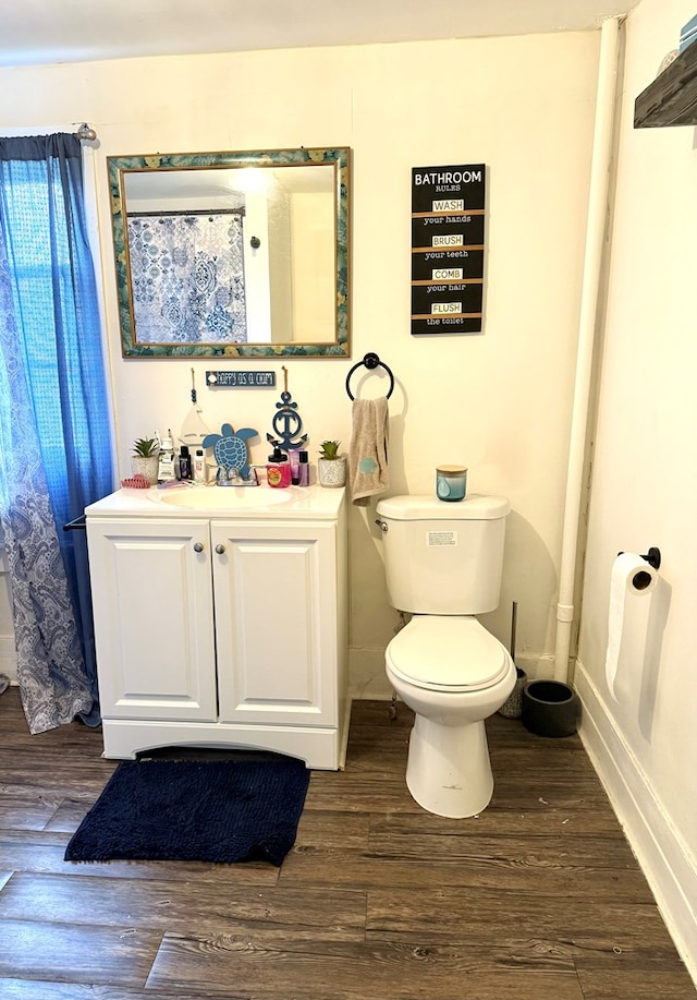 bathroom featuring vanity, hardwood / wood-style flooring, and toilet