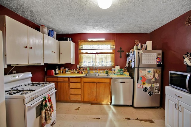 kitchen with sink, white cabinets, appliances with stainless steel finishes, and a textured ceiling