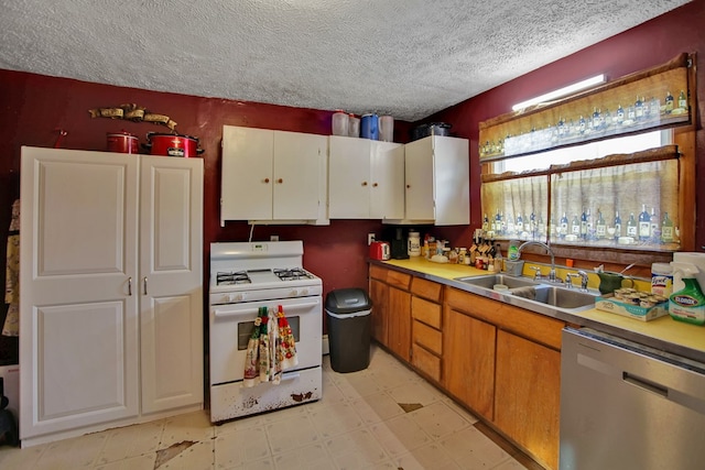 kitchen featuring stainless steel dishwasher, sink, a textured ceiling, and white range with gas cooktop