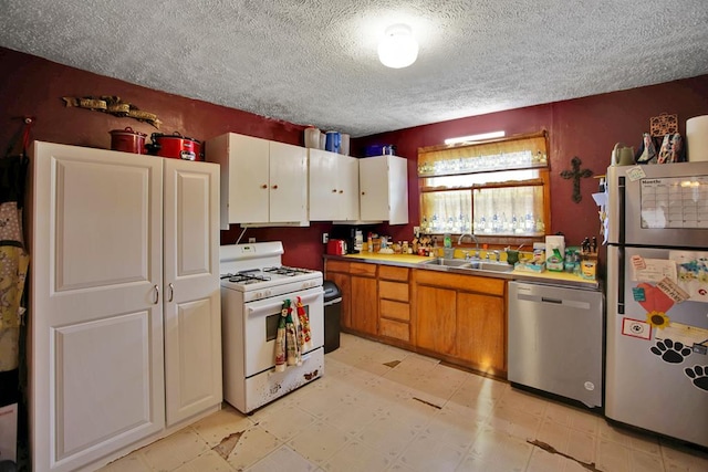 kitchen with sink, a textured ceiling, and stainless steel appliances