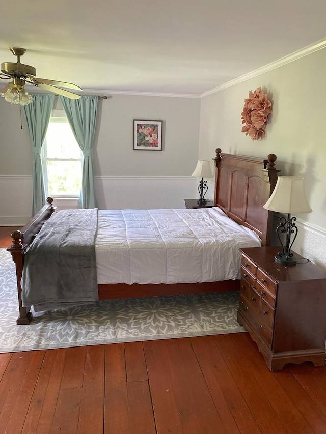 bedroom featuring ceiling fan, ornamental molding, and wood-type flooring