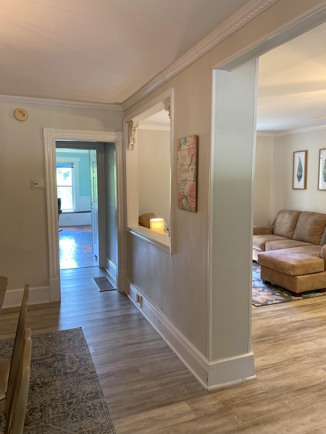 corridor with wood-type flooring and crown molding