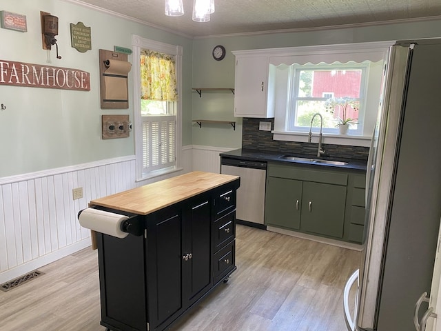 kitchen with sink, crown molding, stainless steel appliances, and light hardwood / wood-style flooring