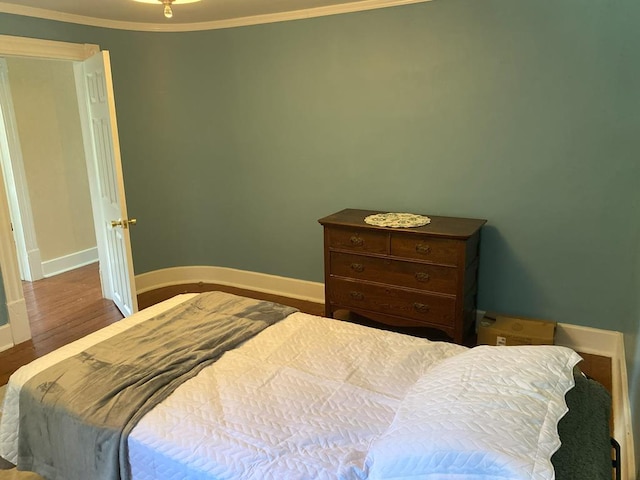 bedroom featuring hardwood / wood-style flooring and ornamental molding