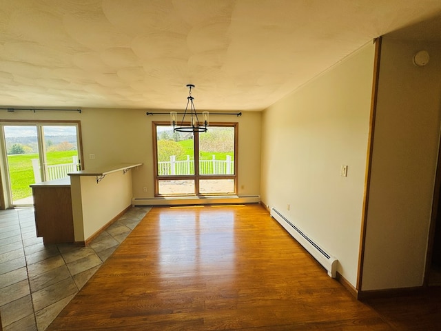 425 Gateway Industrial Park Rd, Athens, PA 18810 - unfurnished room with a baseboard radiator, a notable chandelier, baseboards, and wood finished floors