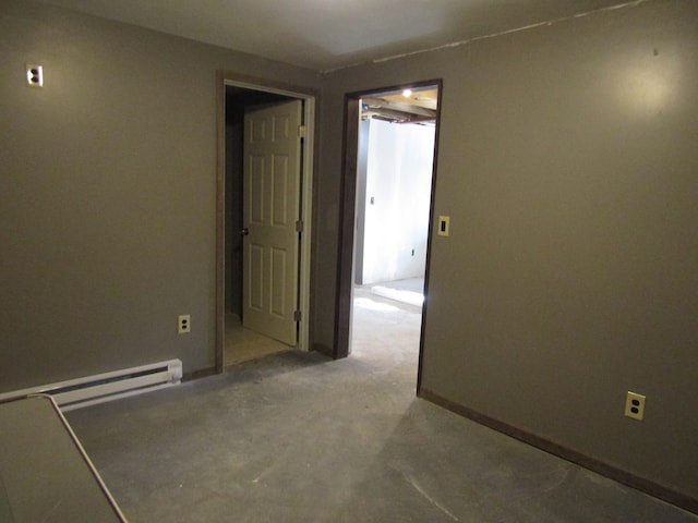 unfurnished room featuring concrete flooring and a baseboard radiator