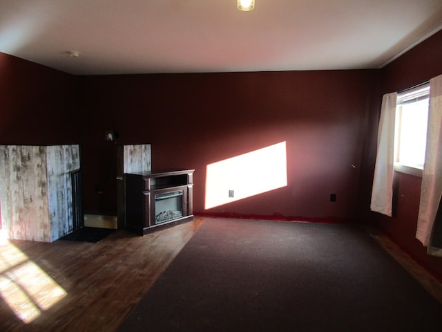 unfurnished living room with dark hardwood / wood-style flooring and a fireplace