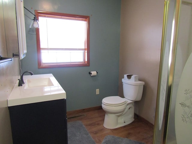 bathroom with hardwood / wood-style floors, vanity, and toilet