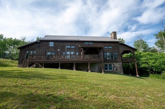 back of property featuring a wooden deck and a yard