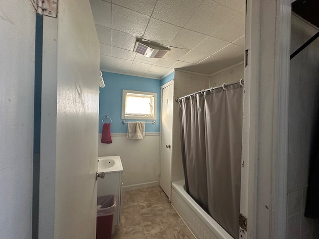 bathroom with visible vents, baseboards, vanity, and shower / bathtub combination with curtain