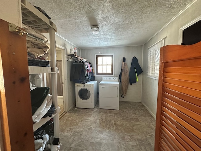 laundry room with laundry area, a textured ceiling, ornamental molding, and washer and dryer