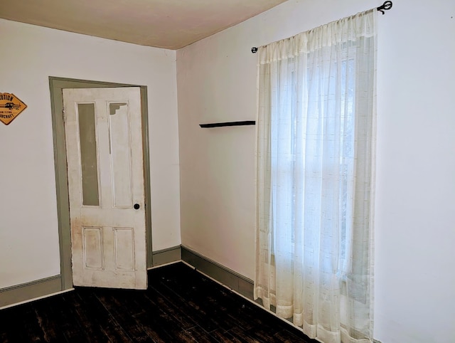 unfurnished room featuring dark wood-type flooring