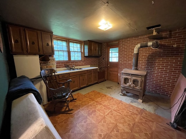 286 Hidden Hollow Farm Dr, Austin, PA 16720 - kitchen with a wood stove, light countertops, and brick wall