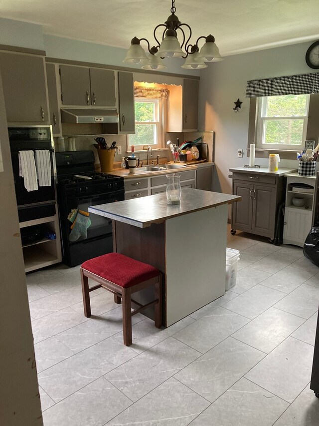 115 Pine St, Galeton, PA 16922 - kitchen with black appliances, under cabinet range hood, a chandelier, a kitchen island, and light tile patterned floors