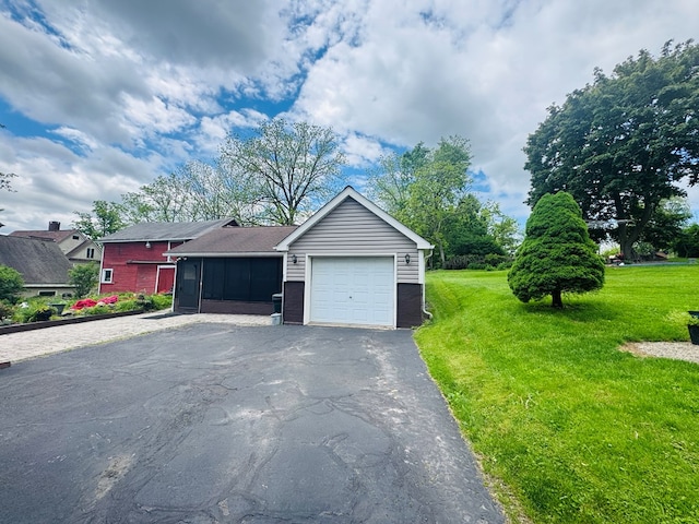 view of front of home with asphalt driveway, a front lawn, an attached garage, brick siding, and a sunroom