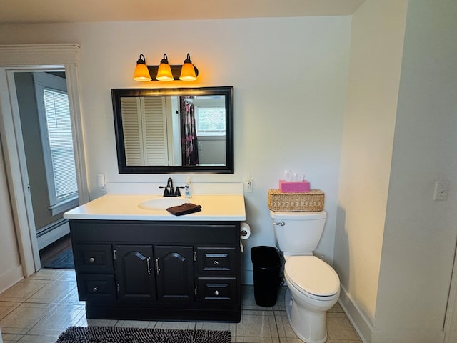 full bathroom with a baseboard heating unit, toilet, baseboards, vanity, and tile patterned floors
