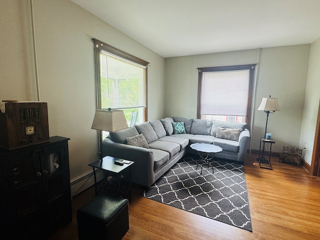 living room with wood finished floors, baseboard heating, and baseboards