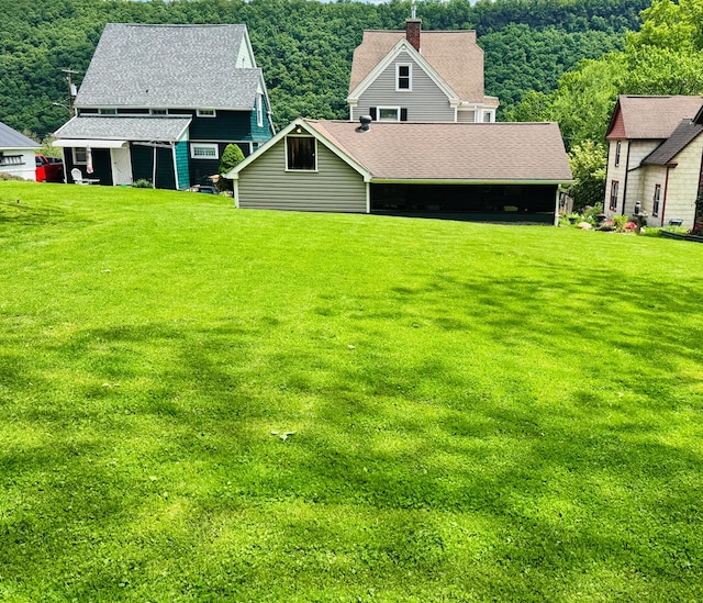 view of green lawn featuring an outbuilding