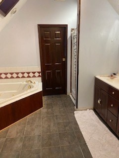 bathroom with tile patterned floors, vanity, and a tub to relax in