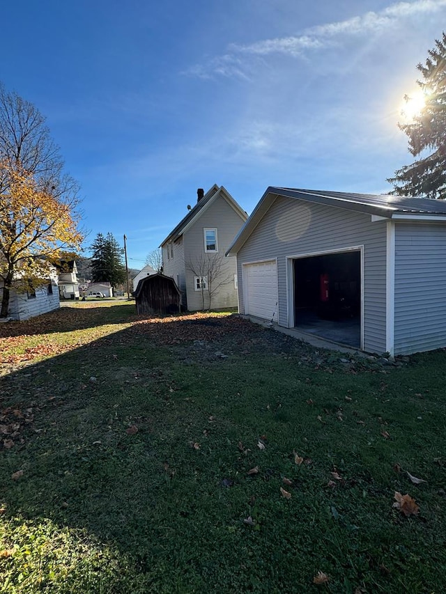 view of home's exterior with a yard, a garage, and an outdoor structure