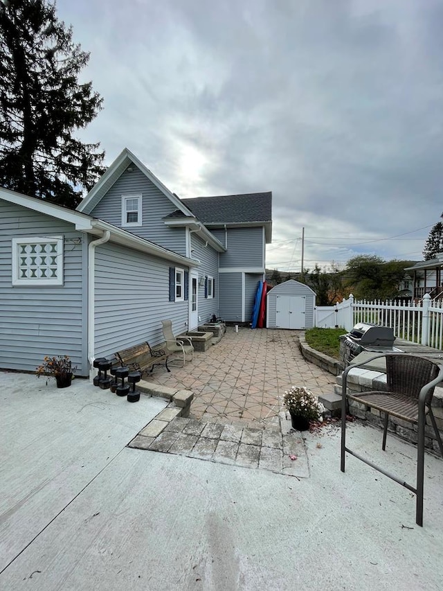 back of property with a storage unit and a patio area