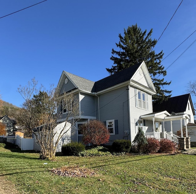 view of side of home with a lawn and a porch