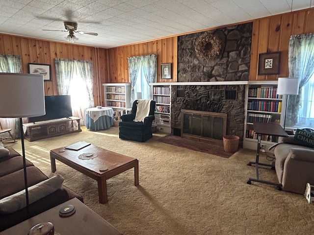 408 S E St, Coudersport, PA 16915 - living room with ceiling fan, wood walls, carpet, and a stone fireplace