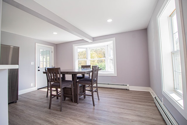 dining area featuring beamed ceiling, a baseboard radiator, and hardwood / wood-style flooring