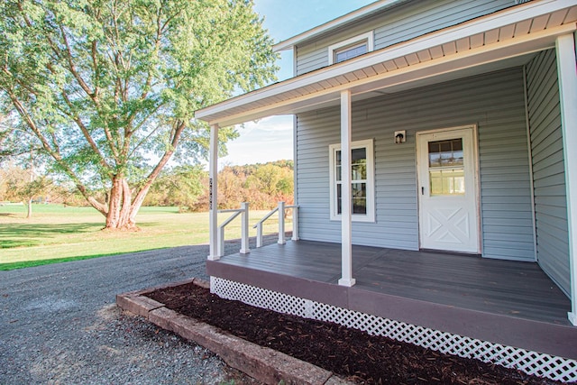 wooden deck with covered porch and a yard