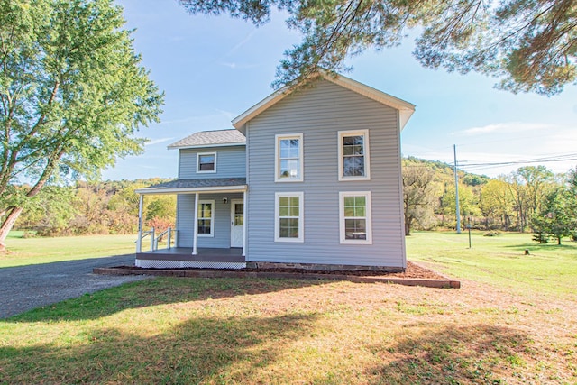 view of property featuring a porch and a front yard